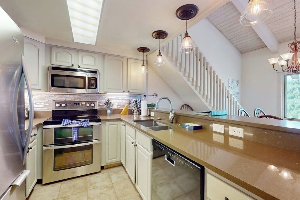 A modern kitchen with stainless steel appliances, a dishwasher, and a large island.