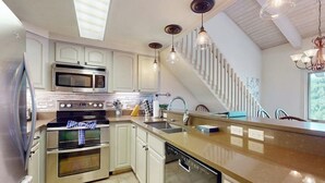 Una cucina moderna con elettrodomestici in acciaio inossidabile, lavastoviglie e un'isola grande.