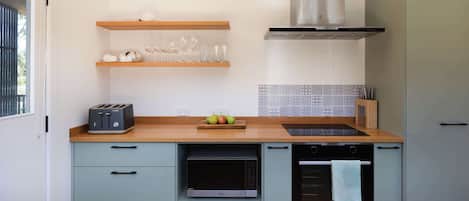 A modern kitchen with a toaster, microwave, oven, and a stainless steel range hood.