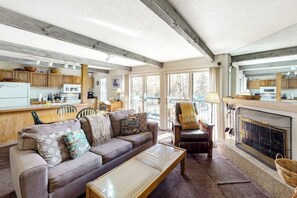 Ein Wohnzimmer mit Sofa, Couchtisch und Kamin.