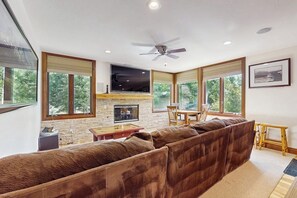 A modern living room with a large sectional sofa, a fireplace, and a dining area. - Mountain Gem Walking Distance From Slopes w/Shared Pool & Hot Tubs, Free WiFi (Snowmass)