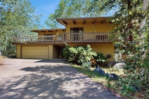 A two-story house with a garage, a balcony, and a driveway.