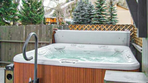 A hot tub with a wooden exterior, a metal ladder, and a wooden deck. - Main Street gem - pool & hot tub - walk to lifts, dog-friendly, third floor (Aspen)