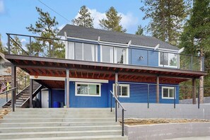 Ein zweistöckiges Haus mit Balkon, Treppe und Garage.