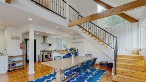 A spacious kitchen with white cabinets, a wooden staircase, and a blue patterned rug. - Dog-OK, updated home with WiFi, Sauna,  game room - close to lakes & hiking (Lake Arrowhead)