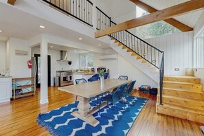 A spacious kitchen with white cabinets, a wooden staircase, and a blue patterned rug. - Dog-OK, updated home with WiFi, Sauna,  game room - close to lakes & hiking (Lake Arrowhead)