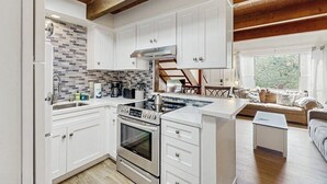 Una cocina moderna con armarios blancos, horno empotrado y una isla grande.
