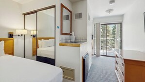 Hotelkamer met een bed, een badkamer met een wastafel, een spiegel en uitzicht op het landschap.