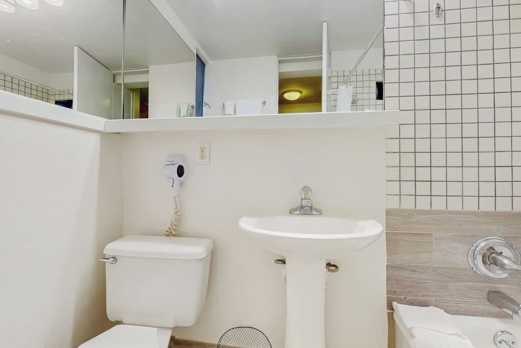 A modern bathroom with a toilet, sink, and mirror.