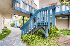 A blue staircase leading to a building entrance, surrounded by greenery and a paved path. - Contemporary Condo | Mountain Views & Balcony | 1 Block to Beach (Carpinteria)