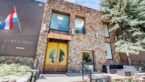 A building with a stone facade, a yellow door, and a sign that reads '31 West Main.' - Main Street studio - pool & hot tub - walk to lifts, dog-friendly, second floor (Aspen)