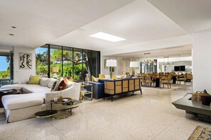 Ein modernes Wohnzimmer mit Ecksofa, Couchtisch und Essbereich mit Stühlen und Tisch.