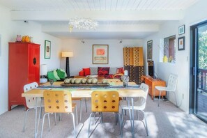 Ein Essbereich mit einem Holztisch, Stühlen, einem roten Schrank und einer Chandelier.
