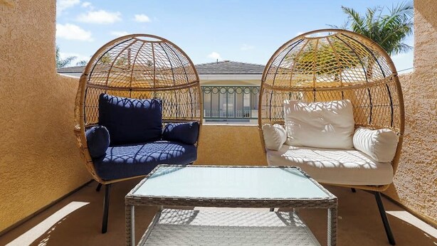 A balcony with two wicker chairs, one blue and one white, and a small table. - Dog-friendly home near beach with fireplace, grill, yard, & W/D (Grover Beach)