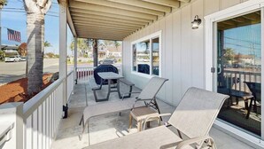 A covered outdoor area with a grill, two lounge chairs, and a table. - Terrific home close to the beach, restaurants, parks, and activities w/free WiFi (Grover Beach)