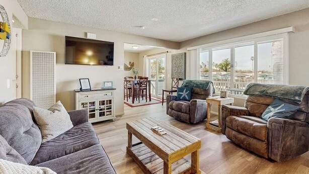 A living room with a sofa, armchairs, a coffee table, and a TV. - Terrific home close to the beach, restaurants, parks, and activities w/free WiFi (Grover Beach)