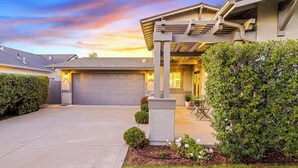 A residential house with a garage, covered porch, and well-maintained garden. - Comfortable home near beach with enclosed yard & patio, W/D, grill (Arroyo Grande)