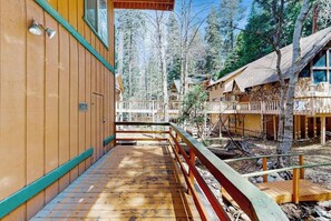 Eine Holzhütte mit einer Terrasse, umgeben von Bäumen.