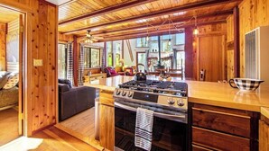 A wooden interior with a kitchen area featuring a stove, oven, and wooden cabinets.
