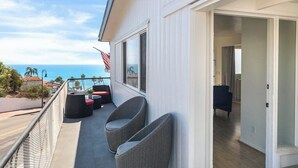 Ein Balkon mit Korbstühlen, einer amerikanischen Flagge und Blick auf den Ozean.