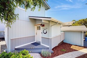Ein modernes, zweistöckiges Haus mit Veranda, Briefkasten und einem gepflegten Garten.