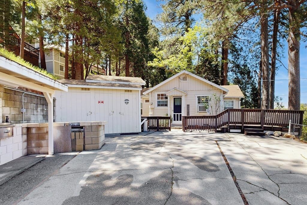 A single-story building with a garage, a small porch, and a wooden fence.