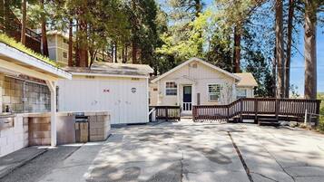 A single-story building with a garage, a small porch, and a wooden fence.