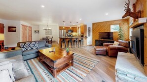 A modern living room with a sofa, a coffee table, and a fireplace. - Inviting ski-in condo with fireplace, hot tubs, & gym (Breckenridge)