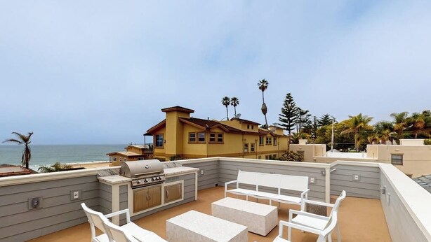 A rooftop patio with outdoor furniture, a grill, and a view of the ocean. - Beautiful Oceanview home with outdoor grill and spacious rooftop (Pismo Beach)