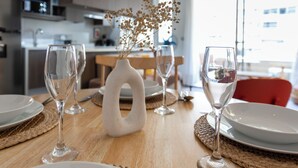 Ett matbord med tallrikar, glas och en vas med torkade blommor.