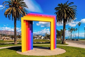 A colorful structure with a clear view of a park, palm trees, and distant mountains.