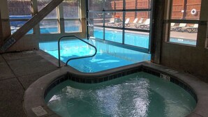 A hot tub with a view of a swimming pool and a wooden deck. - Lovely Townhouse in Prime Location w/Shared Pool, Hot Tub - Near Downtown/Lifts (Breckenridge)