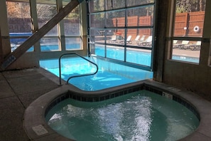 A hot tub with a view of a swimming pool and a wooden deck. - Lovely Townhouse in Prime Location w/Shared Pool, Hot Tub - Near Downtown/Lifts (Breckenridge)