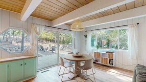 Un espace repas comprenant une table ronde, des chaises et un luminaire suspendu.