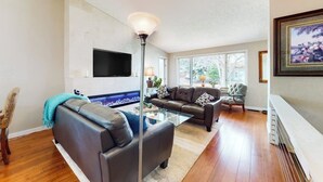 Ein Wohnzimmer mit einer Couch, einem Hocker und einem Couchtisch.