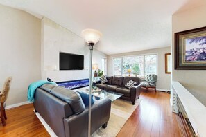 A living room with a sofa, ottoman, and a coffee table. - Inviting home with private hot tub, amazing deck & prime location (Carbondale)