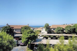 A residential area with houses, parked cars, and a clear view of the sea. - Monarch Vista: Updated Ocean-View Gem | Heated Pool & Spa, Walk Everywhere (Dana Point)