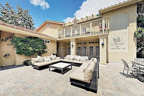 Ein Innenhof mit Lounge-Bereich, Sitzgelegenheiten im Freien und einem Balkon.