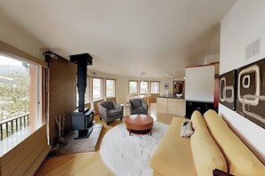 Ein modernes Wohnzimmer mit Kamin, Sofa und Essbereich.