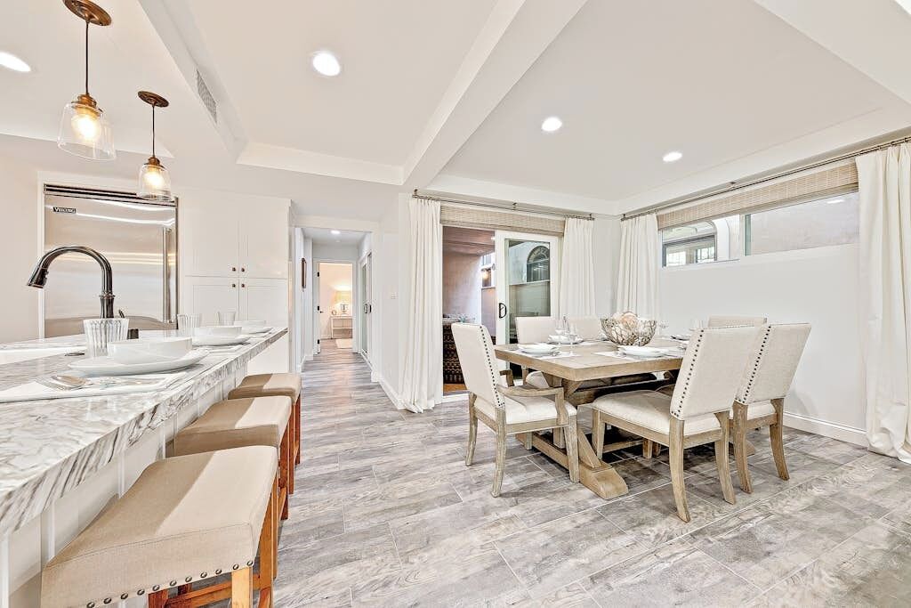 A modern kitchen with a marble countertop, a built-in sink, and pendant lighting.