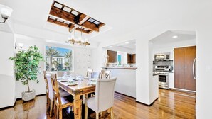 Eine moderne Küche mit Holzausstattung, einem Einbauofen und einem Essbereich mit Holztisch und Stühlen.