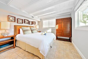 A bedroom with a bed, bedside tables, a wardrobe, and a window with blinds. - Beautiful oceanfront with deck & private road (Dana Point)