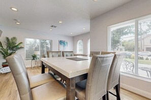 A dining area with a large table and chairs, a potted plant, and a view of the outside. - Dual homes with 2 full kitchens, fast WiFi, fireplace, & patio - dog-friendly (Newport Beach)