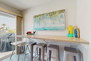 Eine moderne Küche mit Bar, Barhocker und einem Bild an der Wand.