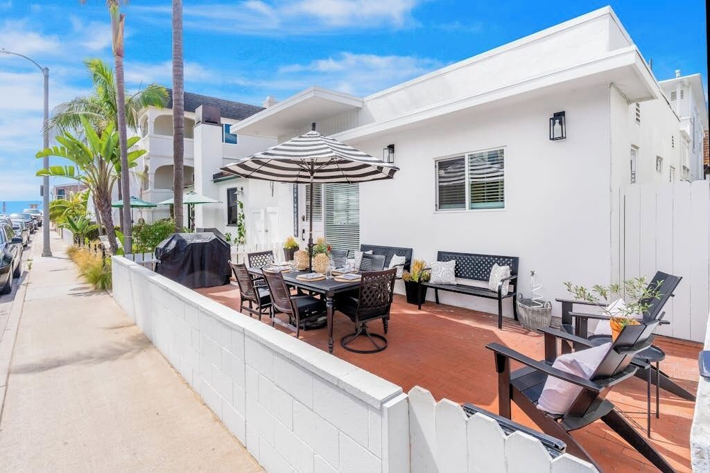 Une terrasse avec une table et des chaises, un barbecue et un coin salon comprenant un canapé et des fauteuils.