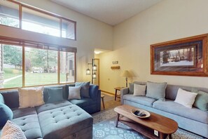 Ein Wohnzimmer mit einem Ecksofa, einem Couchtisch und einem Bild an der Wand.