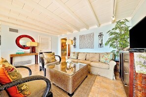 A living room with a sofa, chairs, a coffee table, a TV, and a plant. - Duplex with breathtaking ocean views (Dana Point)