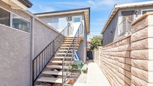 A narrow outdoor corridor with a staircase leading to a door marked '20'. - Convenient dog-friendly condo with free WiFi - right up from the beach (San Clemente)