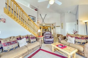 Ein Wohnzimmer mit Treppe, Ledersesseln und einem Holztisch.