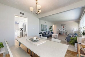 A modern living space with a dining area, kitchen, and seating area. - Charming Orange Circle home with patio, grill, & game room - near Disneyland (Orange)